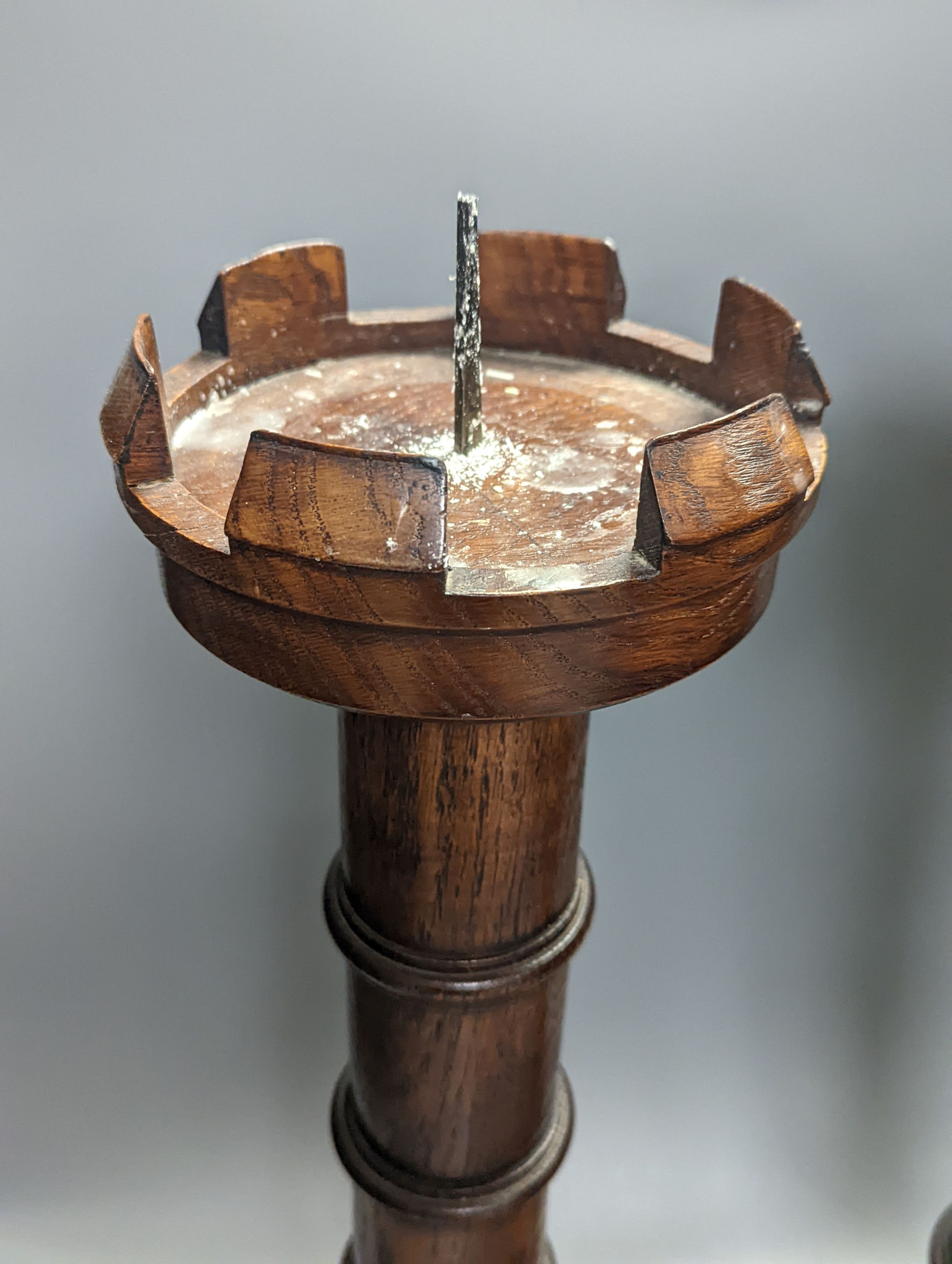A pair of Pugin inspired Gothic style oak pricket candlesticks, height 56cm